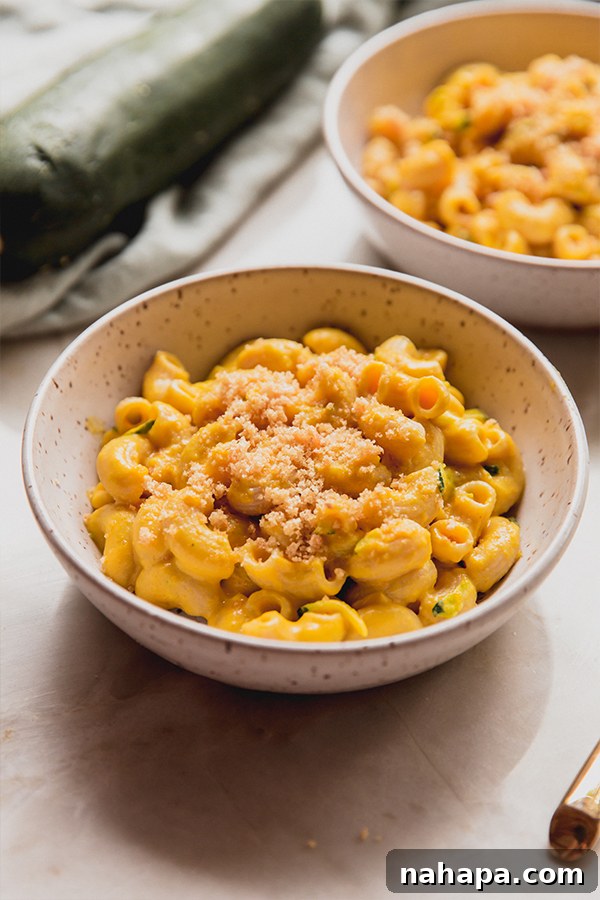 Two bowls of Zucchini Mac and Cheese artfully arranged on a clean kitchen counter, highlighting the appealing presentation of the dish.