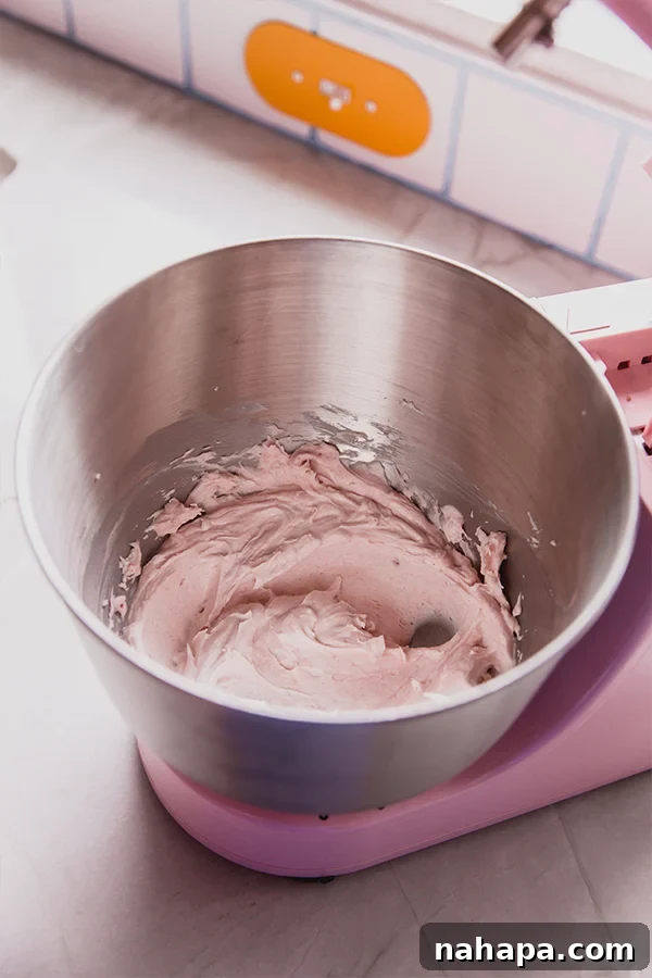 A metal mixing bowl with the icing after mixing.
