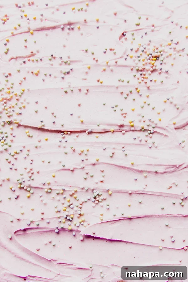 A tray of funfetti pink sugar cookie bars with pink icing and sprinkles.