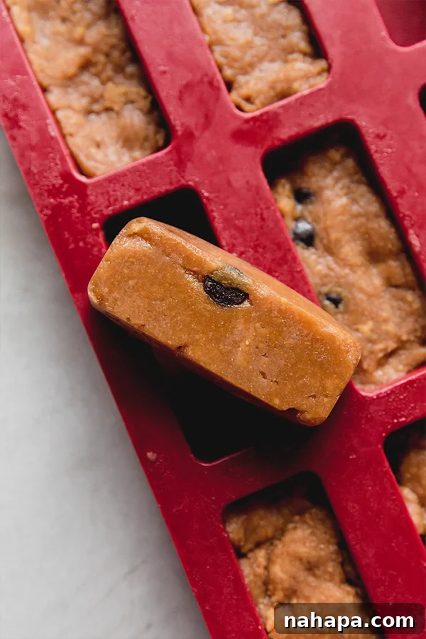 Several cookie dough protein bars setting within a silicone bar mold, showing their neat and uniform shapes before being removed.