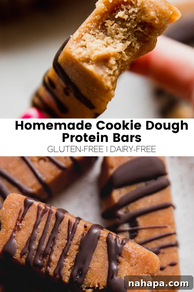 A high-angle shot of a batch of perfectly shaped homemade cookie dough protein bars, some with chocolate drizzle, arranged on a baking sheet.