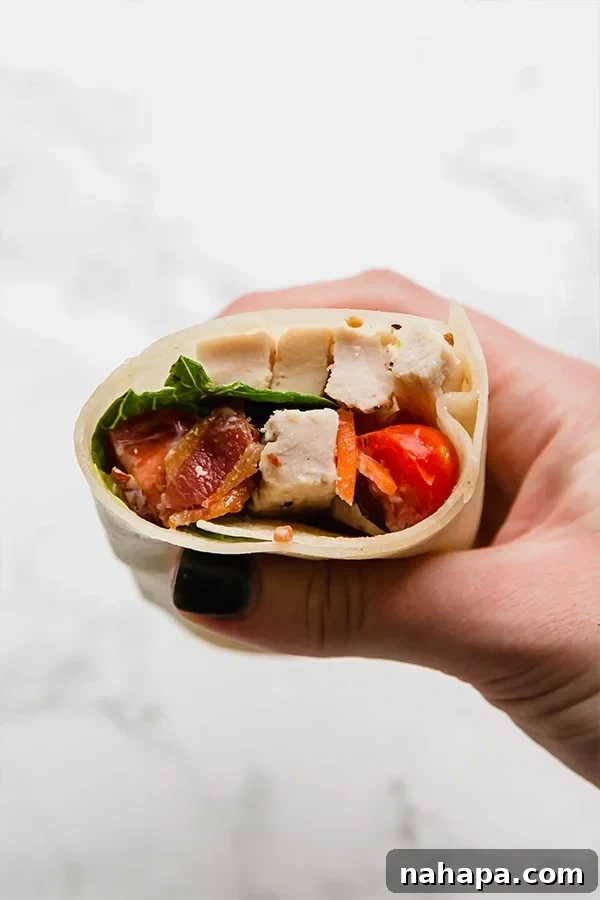 15 Simple Gluten and Dairy Free Lunch Solutions 5 A savory bacon chicken ranch wrap, cut in half, showcasing the filling of chicken, bacon, and greens.
