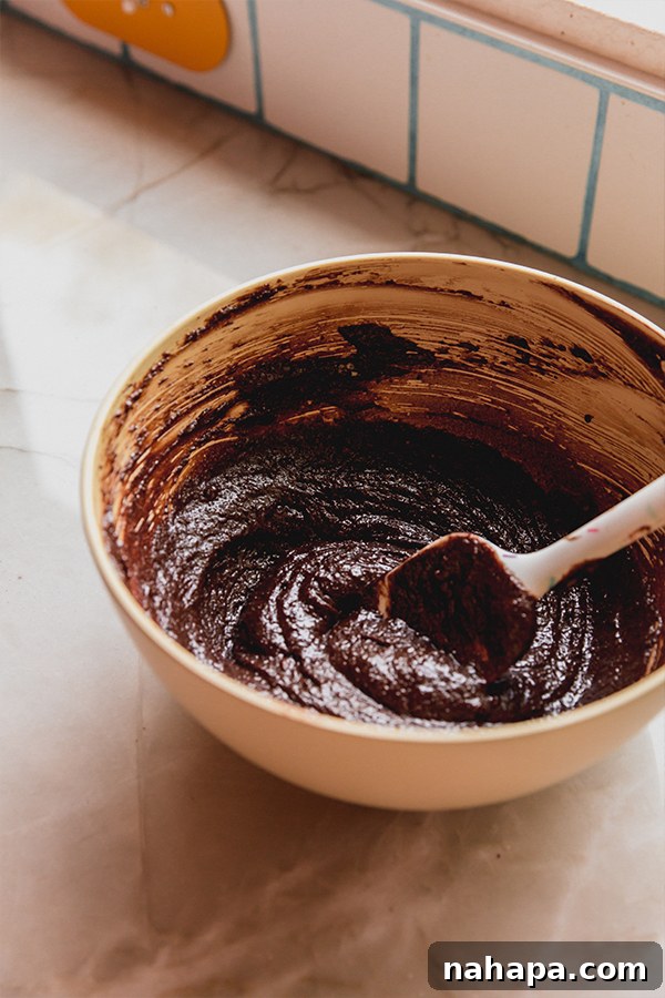 Mixing the brownie batter until smooth and fully combined