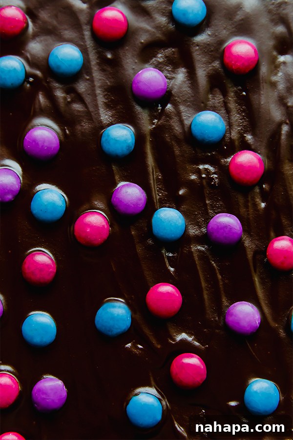 Applying chocolate ganache and Unreal crispy quinoa gems to cooled brownies
