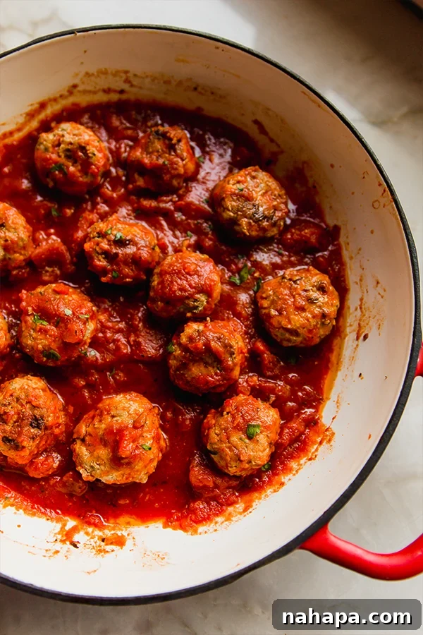 A pot filled with cooked hidden veggie meatballs, glistening in a light sauce, ready to be served.