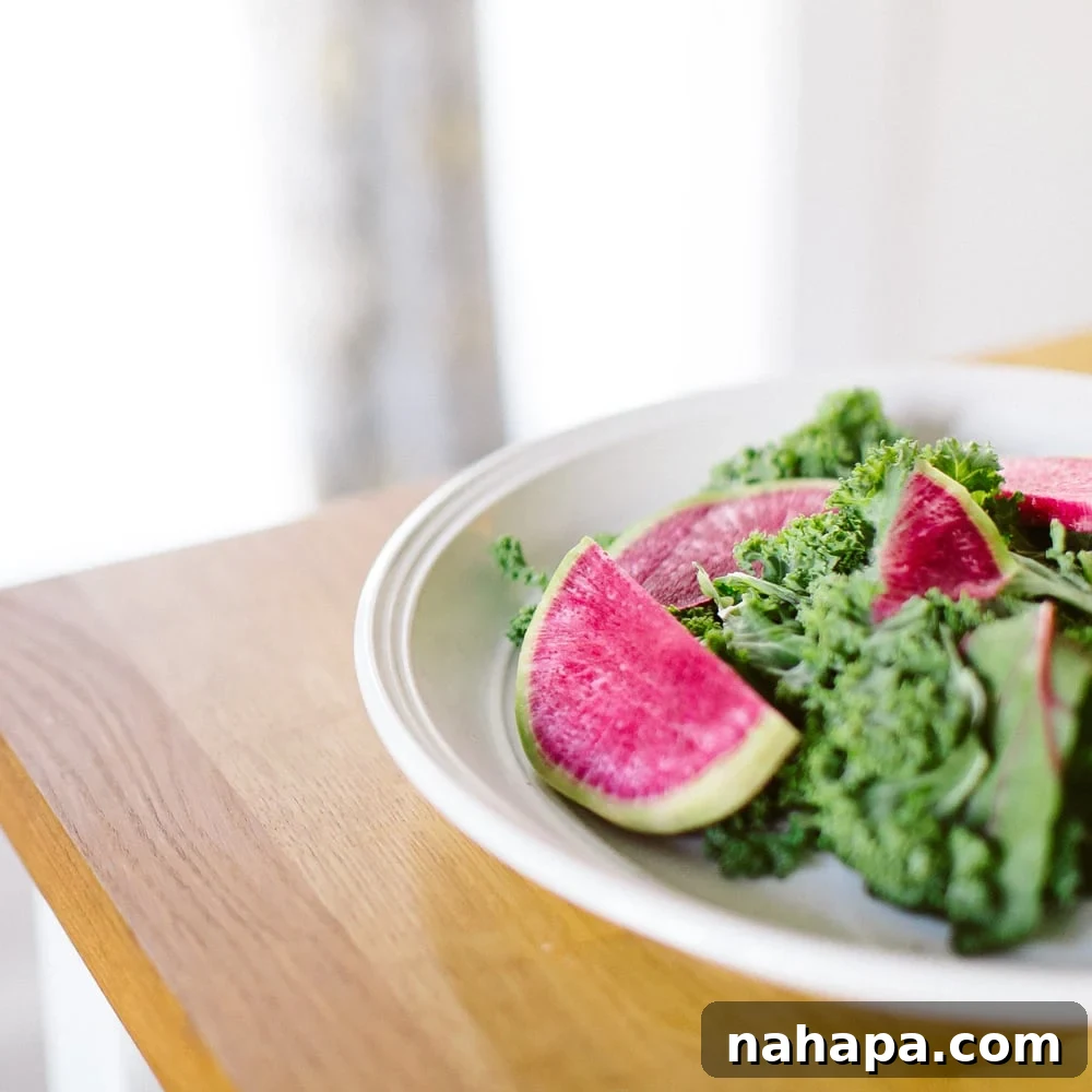 Kale salad with radishes on a white plate. 