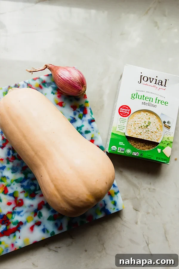 Various fresh and packaged ingredients for butternut squash stelline pasta arranged neatly on a kitchen counter, showcasing the vibrant colors of the squash, herbs, and other components.