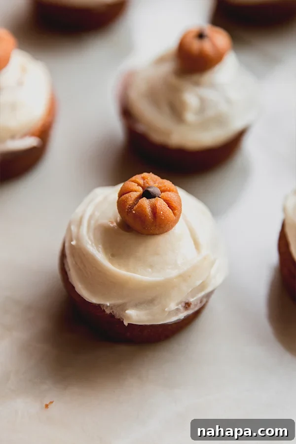 Delicious Gluten-Free and Dairy-Free Pumpkin Spice Cupcakes 4 Decorated pumpkin spice cupcakes artfully arranged on a kitchen counter, ready for enjoyment.