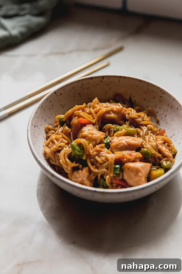 A beautifully plated bowl of gluten-free ramen noodle bake, garnished with green onions, resting on a rustic kitchen counter, ready to be enjoyed.