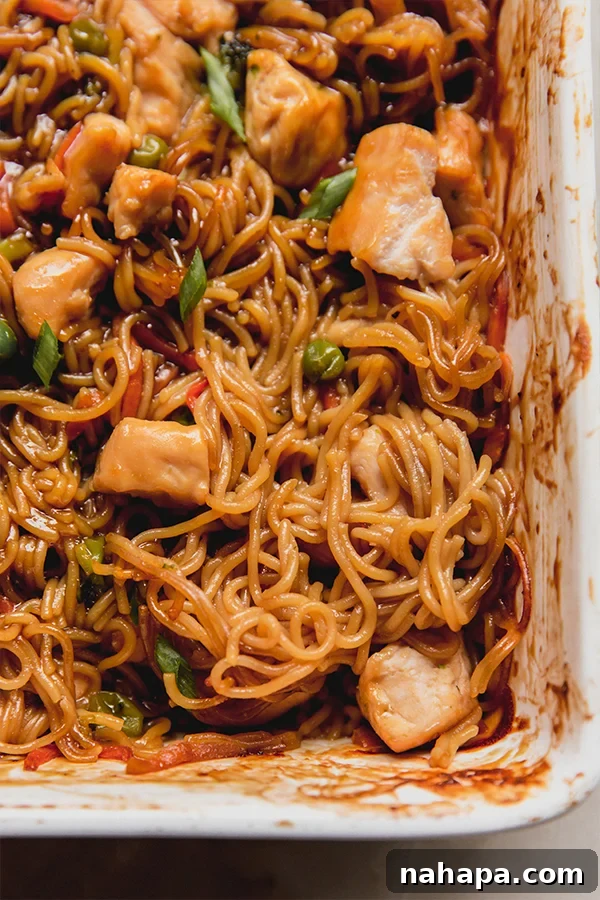 A close-up photograph of the gluten-free ramen noodle bake, showcasing the tender chicken, vibrant vegetables, and perfectly coated ramen noodles.