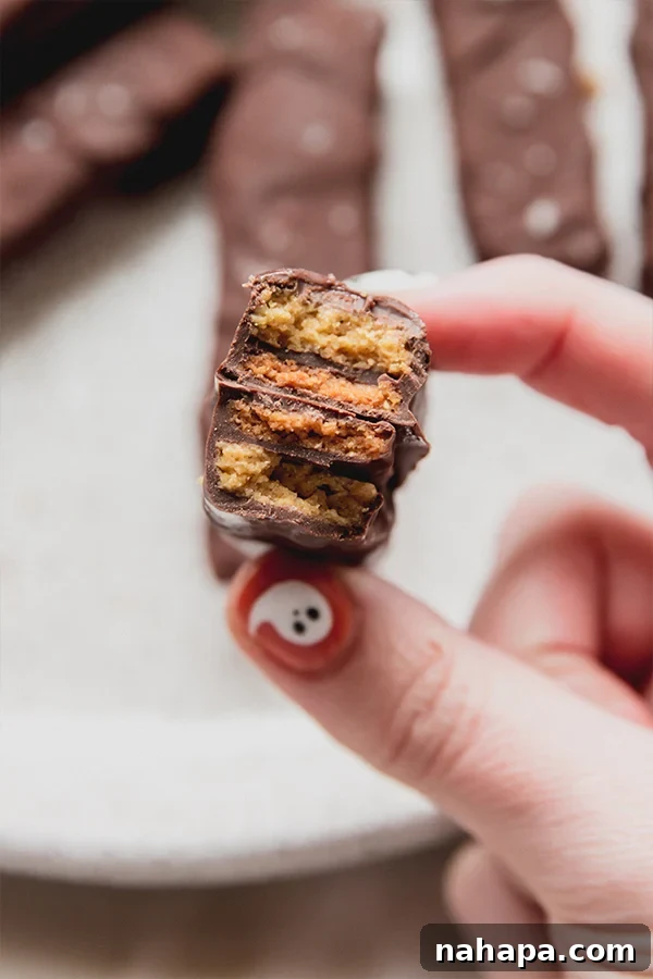 A Kit Kat bar folded in half being held in a hand.