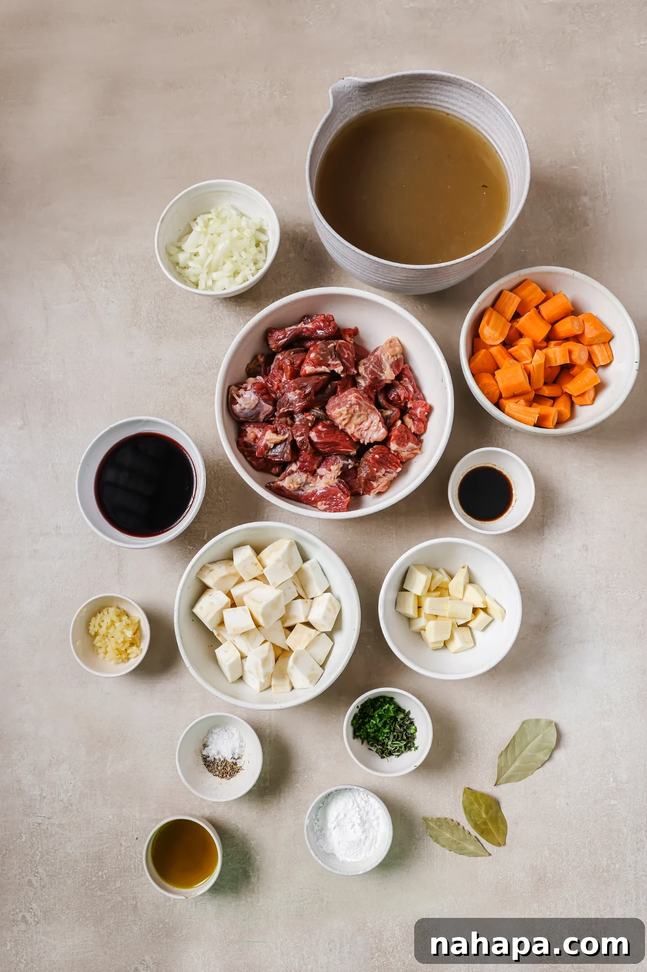 Various fresh ingredients for Dutch oven beef stew laid out in individual bowls.