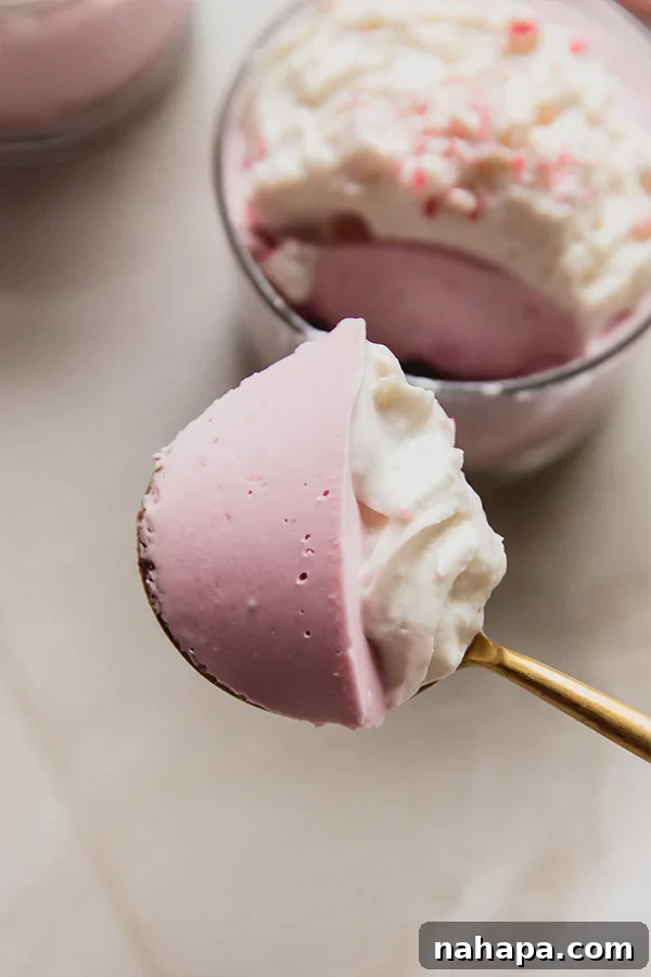 Gluten and Dairy Free Mini Peppermint Pie Cheesecake Cups 4 A spoon with a bite of mini peppermint pie cups on it, showing the creamy texture and crust.