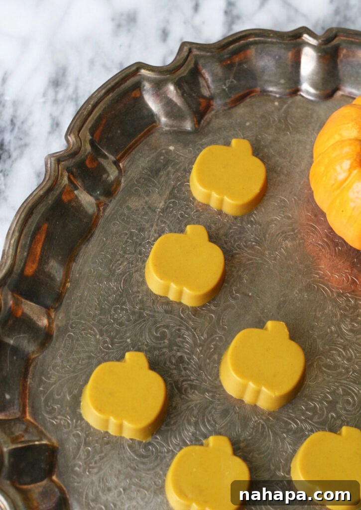 Turmeric gummies in a pumpkin shape on a brass platter, showcasing their vibrant color and festive design.