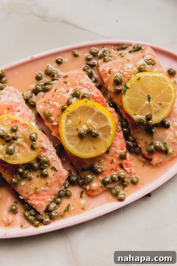 Flavorful Salmon Piccata Without Gluten or Dairy 2 A serving platter of salmon piccata topped with capers and lemon slices.