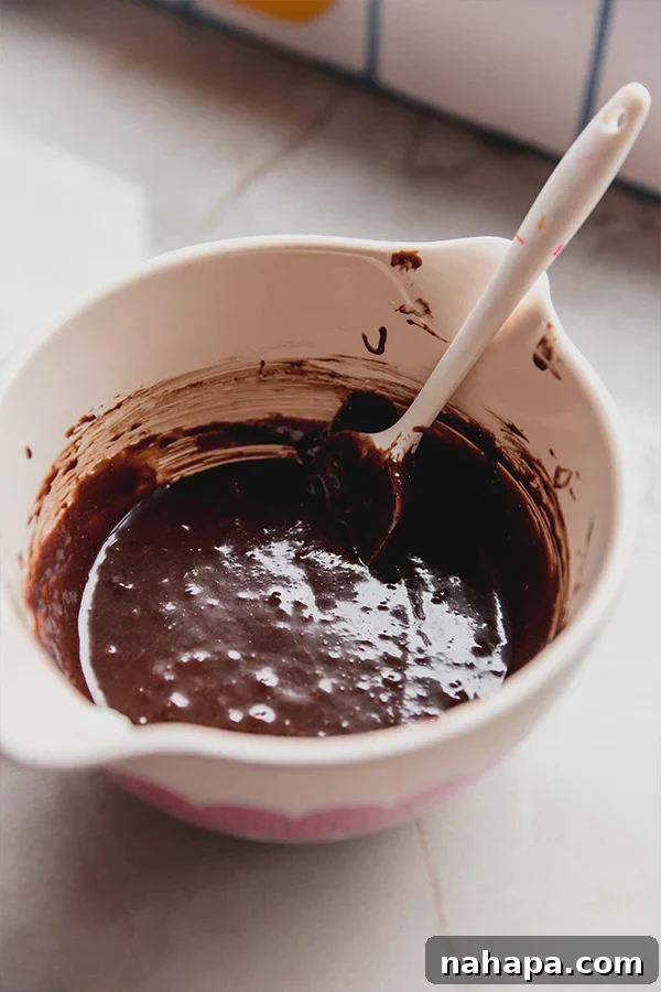 A mixing bowl filled with batter for chocolate lava cakes, ready to be poured into molds.