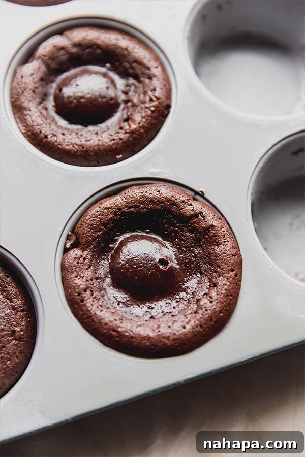 A pan of freshly baked chocolate lava cakes, golden brown and perfectly risen.