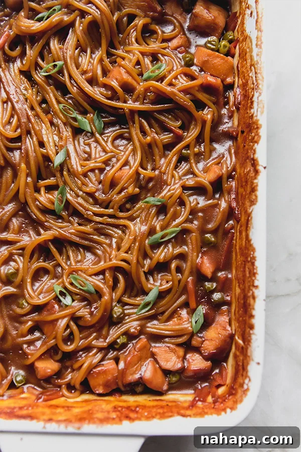 Sticky Honey Garlic Chicken Noodle Bake Gluten Free 5 A baking dish with baked honey garlic chicken noodle dish fresh from the oven, garnished with green onions.