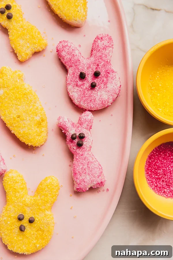 A close-up view of a serving plate brimming with homemade Peeps in various Easter shapes, coated in vibrant yellow and pink natural sugars, showcasing their charming and delicious appearance.