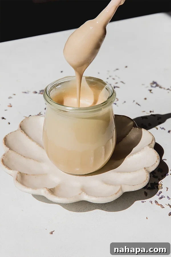 A bowl of Homemade Lavender Whipped Honey with a whisk dripping honey, ready to be served.