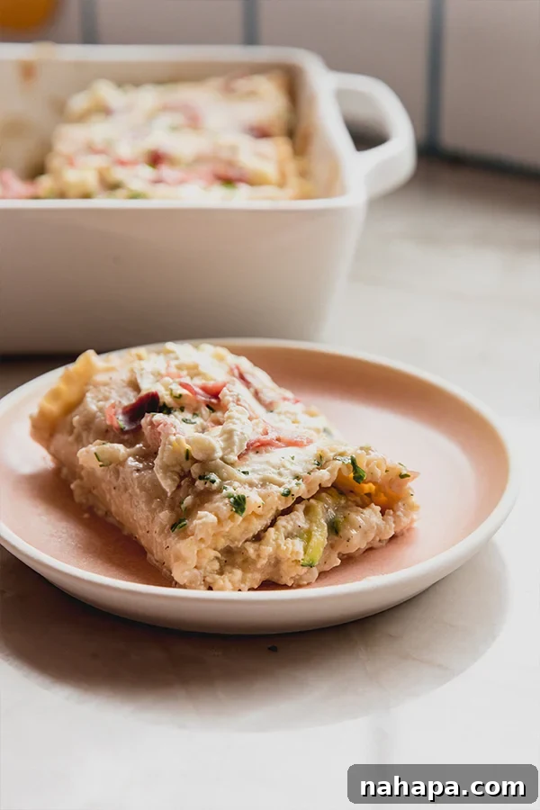A perfectly portioned serving of chicken alfredo lasagna roll ups, beautifully presented on a plate and garnished with fresh parsley.