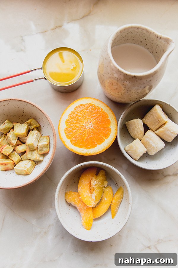 Wendy's Inspired Dairy-Free Creamsicle Frosty 3 All the whole-food ingredients including frozen banana, peach, Japanese sweet potato, orange segments, coconut milk, orange juice, and vanilla extract, laid out and ready to make a delicious creamsicle frosty.