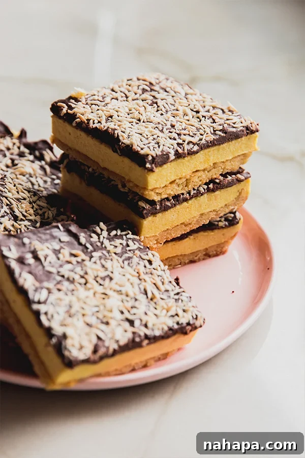 A beautifully arranged lemon coconut s'mores bar, showcasing the crispy base, fluffy marshmallow, and rich chocolate ganache topped with golden toasted coconut, ready to be enjoyed.