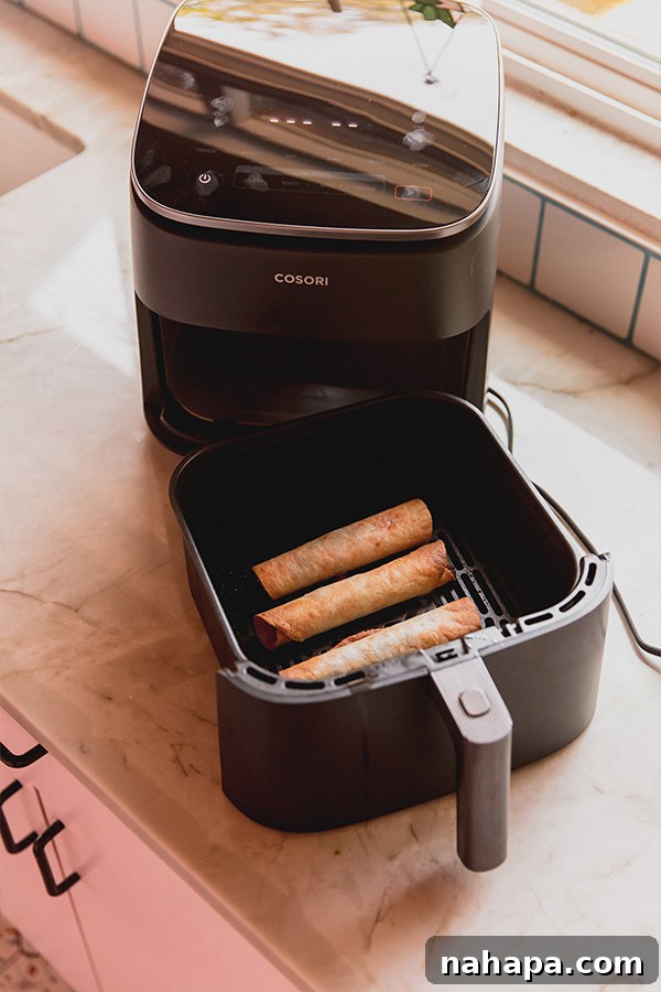 Wholesome Gluten-Free Veggie Pizza Bites 6 Air Fryer Veggie Pizza Roll-Ups cooking in the Cosori TurboBlaze air fryer basket, achieving a crispy texture