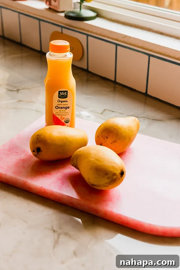 Freshly cubed Ataulfo mangoes and a container of orange juice, the two simple ingredients for the sorbet.