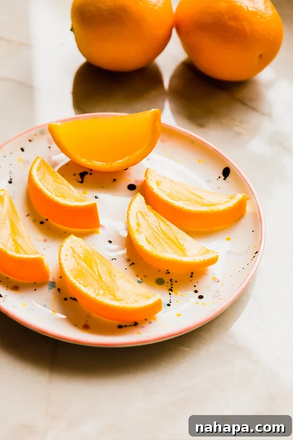 Various orange jello slices arranged on a white platter, showcasing the beautiful presentation within the orange peels.