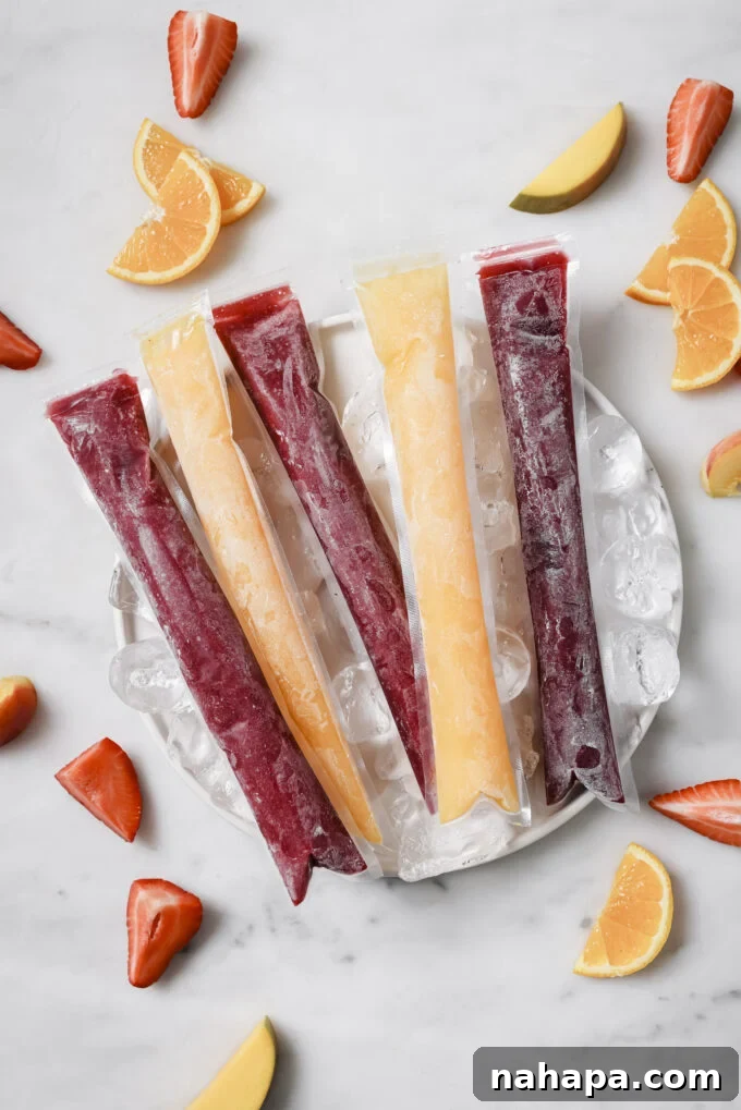 Two hands holding a strawberry-beet freezer pop outdoors