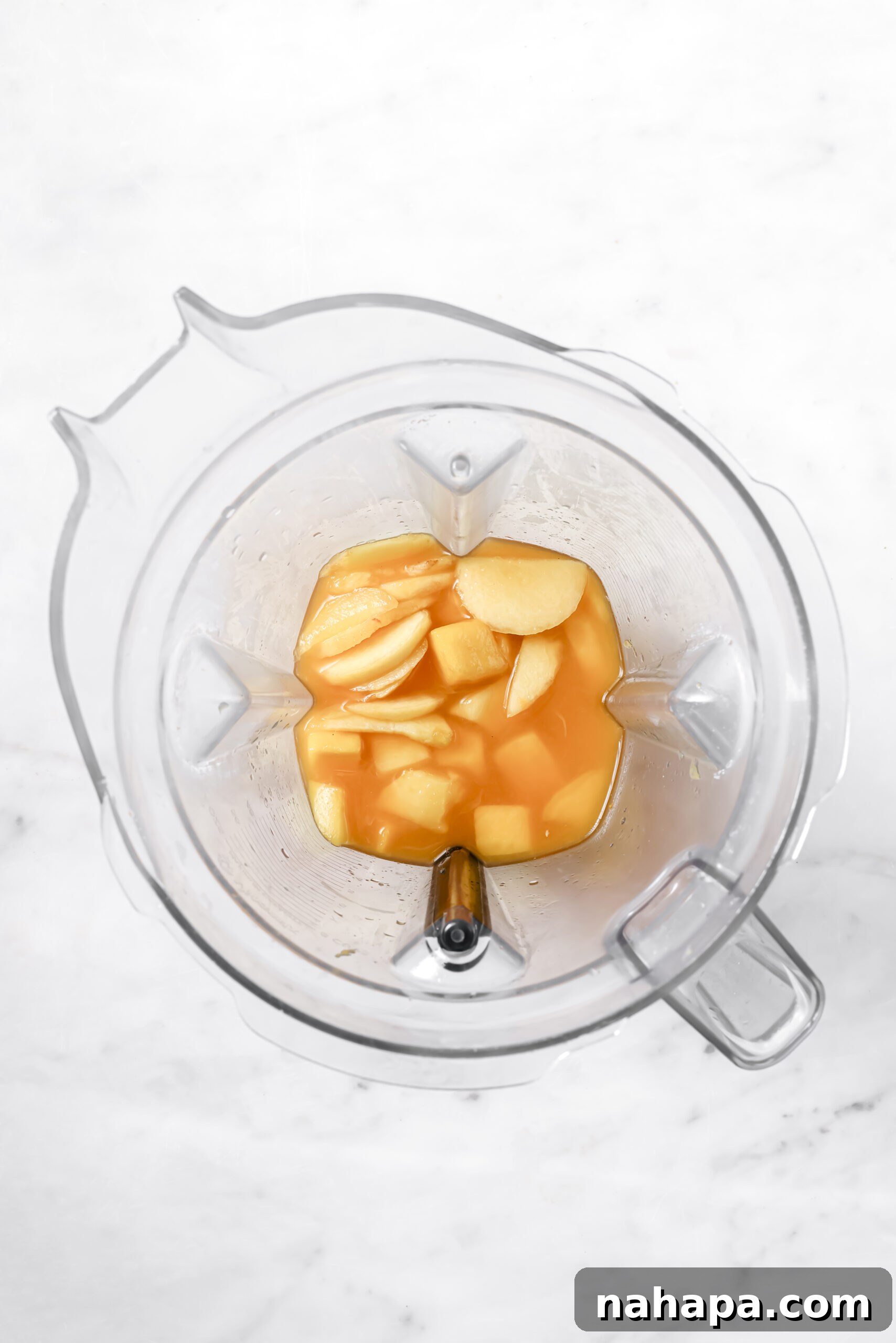 Blended mango-peach mixture in a blender jar