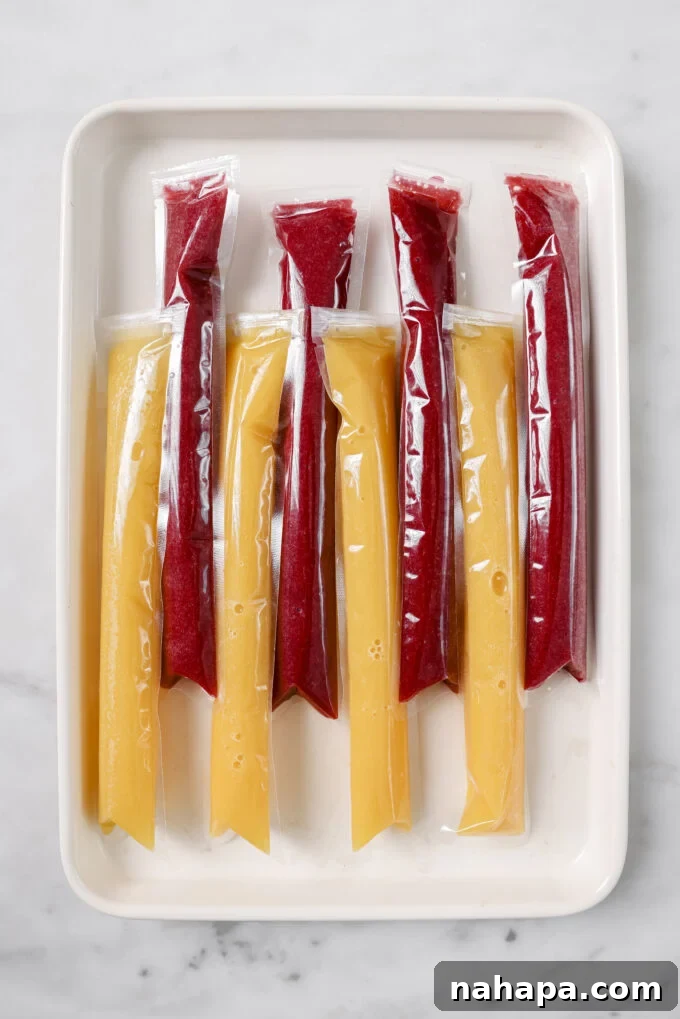 Several freezer pops neatly arranged on a baking sheet inside a freezer