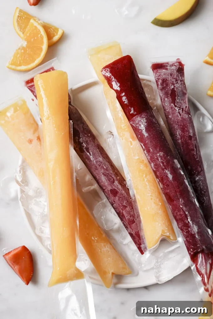 Several strawberry-beet freezer pops arranged aesthetically on a rustic wooden board