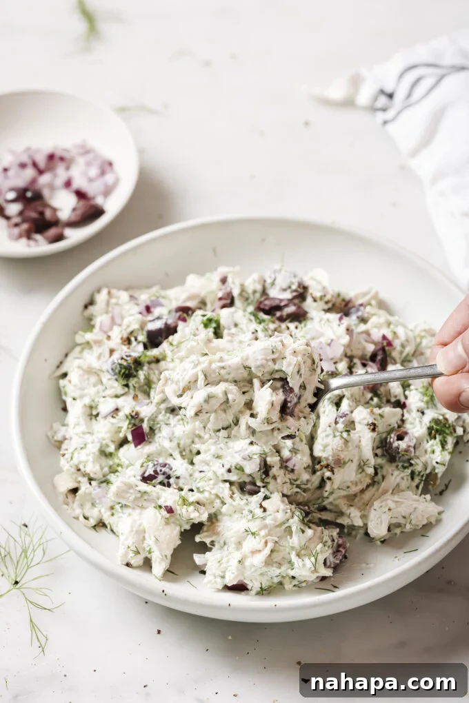 Fresh Tzatziki Chicken Salad in a bowl, garnished with dill and served with fresh vegetables.