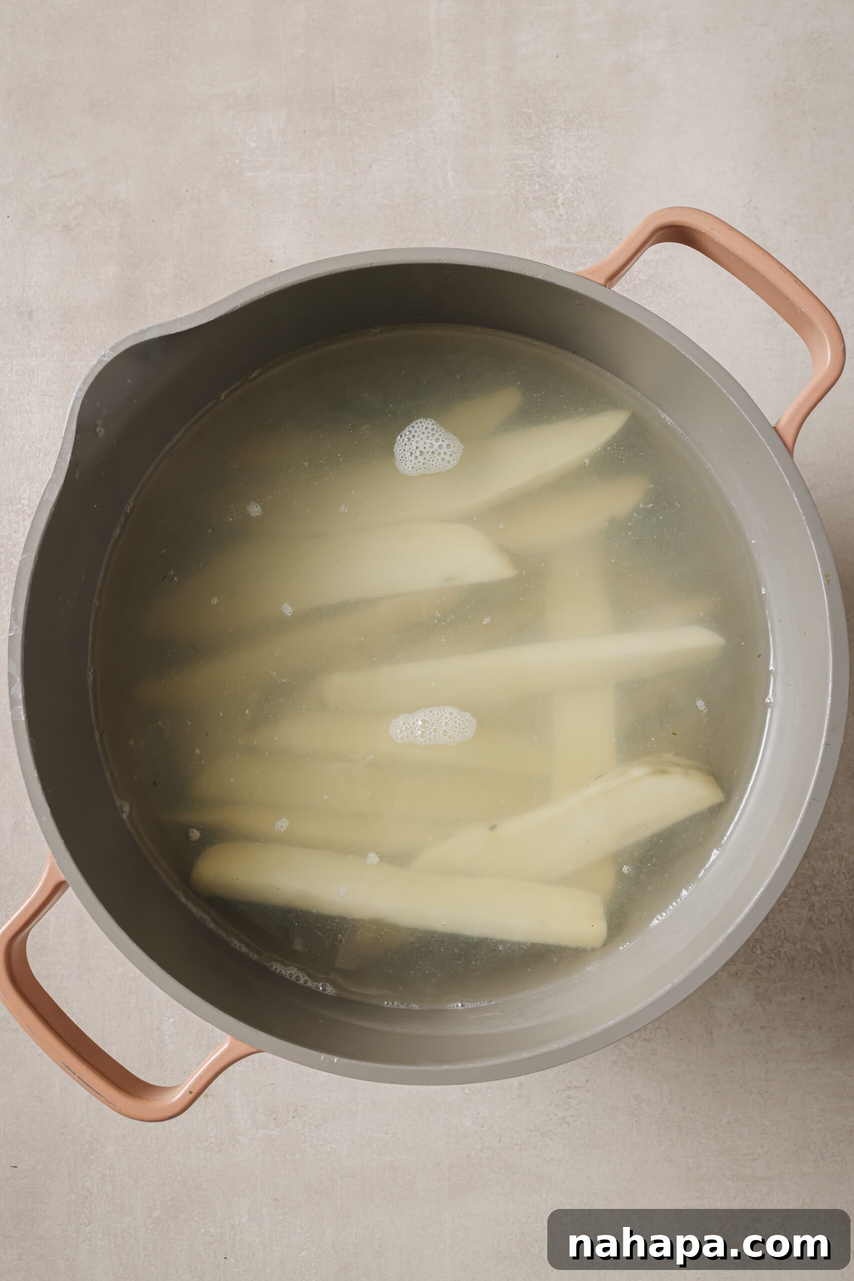 Japanese sweet potato fries parboiling in boiling water, a crucial step for achieving crispiness.