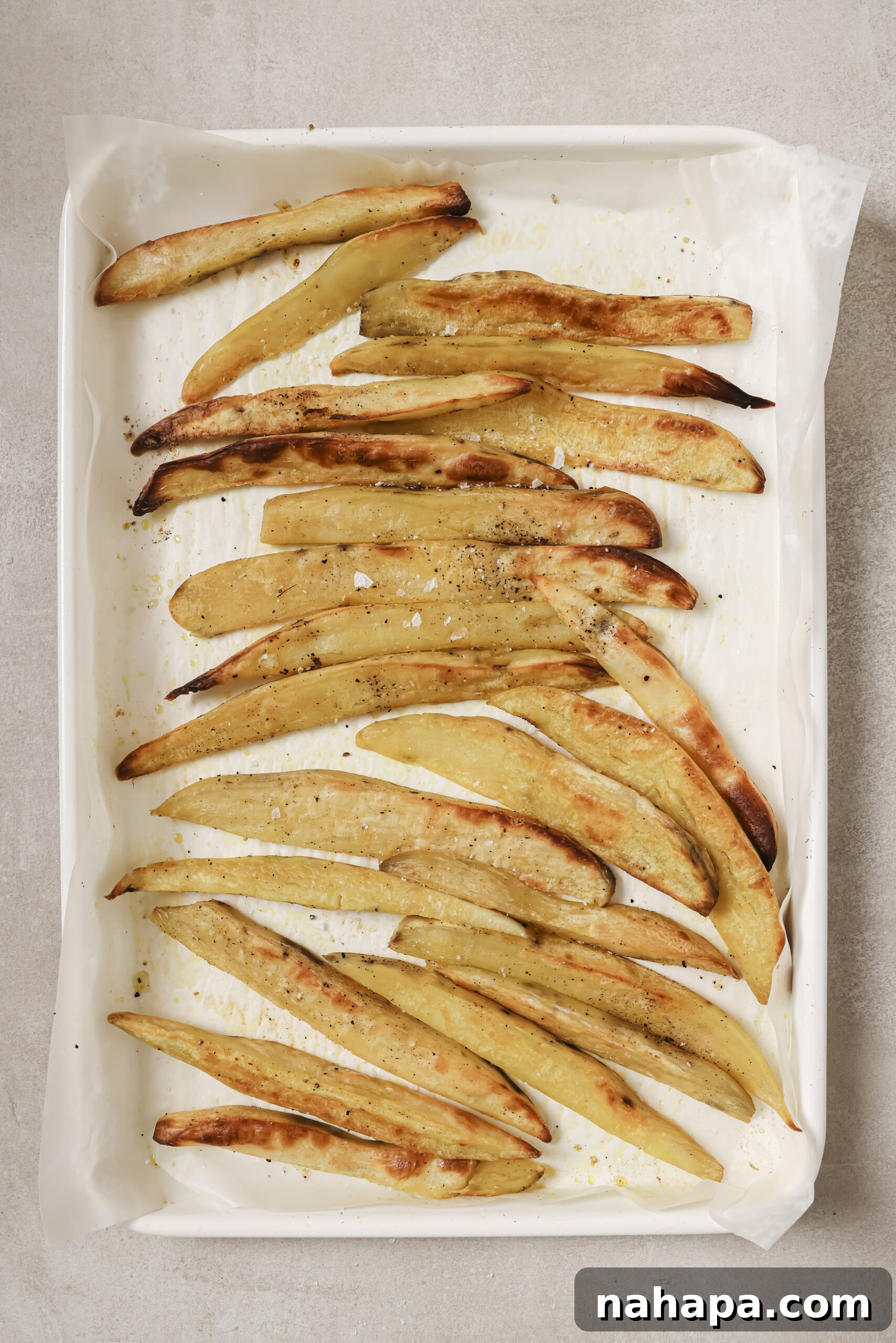 Freshly baked crispy Japanese sweet potato fries, hot out of the oven, with a perfect golden crust.
