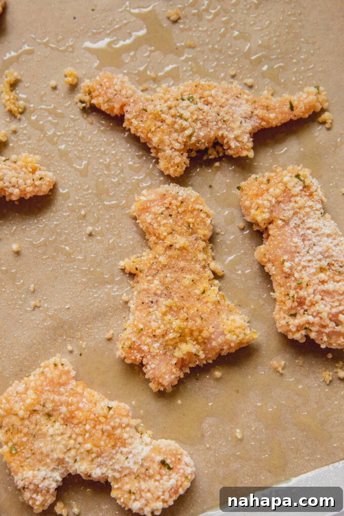 Raw dino-shaped nuggets on parchment paper.