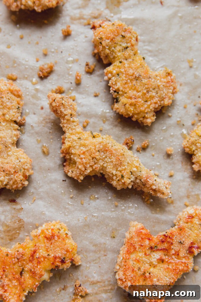 Gluten-free dino nuggets on parchment paper.