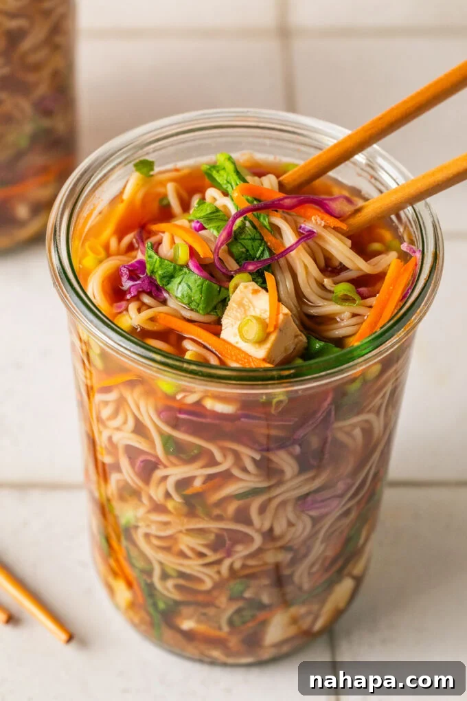 Elevated Gluten-Free Noodle Cups: Healthy Homemade Comfort 11 Homemade cup of noodles with ramen, veggies and broth in a glass jar with chopsticks pulling the noodles.