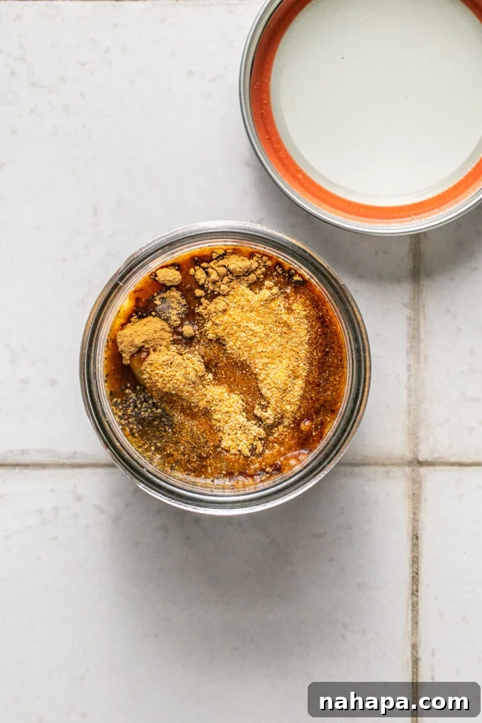 Elevated Gluten-Free Noodle Cups: Healthy Homemade Comfort 4 Small glass jar with chicken bouillon, seasonings and coconut aminos, unmixed.