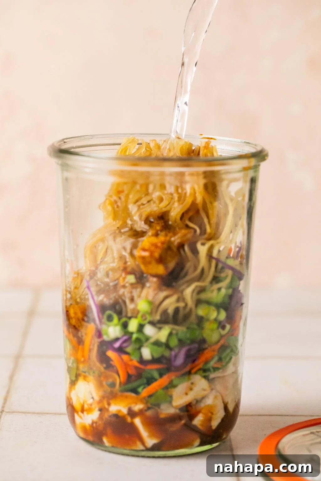Elevated Gluten-Free Noodle Cups: Healthy Homemade Comfort 8 Cooked chicken, veggies, green onion, a brick of gluten free ramen layered in a glass jar with hot water pouring in.