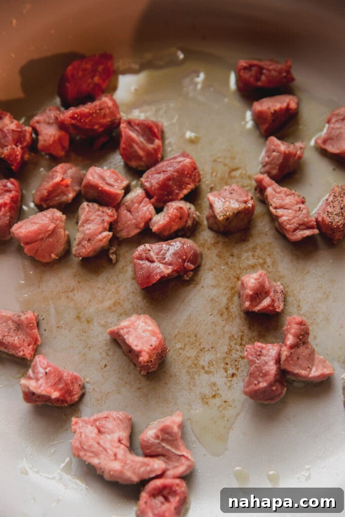 Cubed steak, raw cooking in a pan with oil.