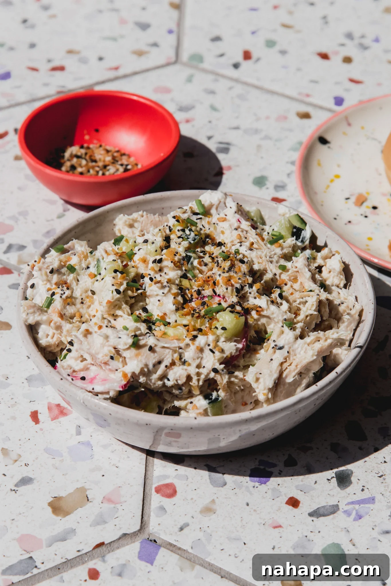 Bagel chicken salad topped with everything bagel seasoning in a bowl.