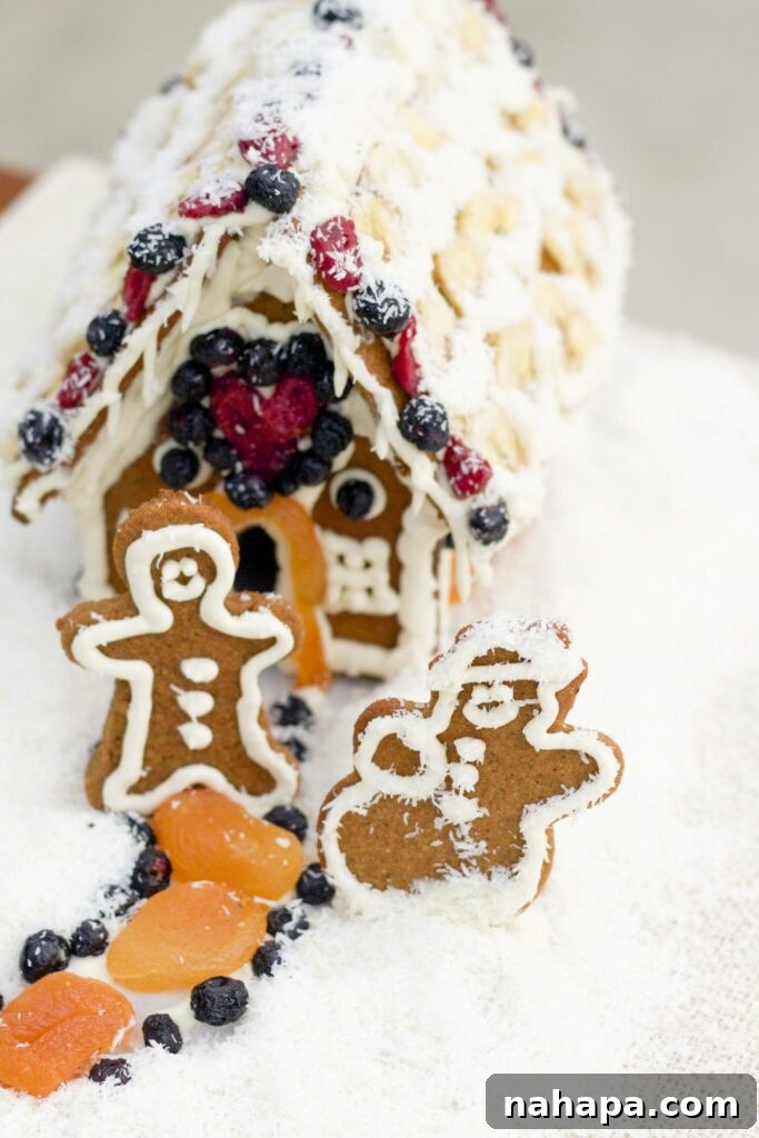 A gingerbread house with two gingerbread people outfront.
