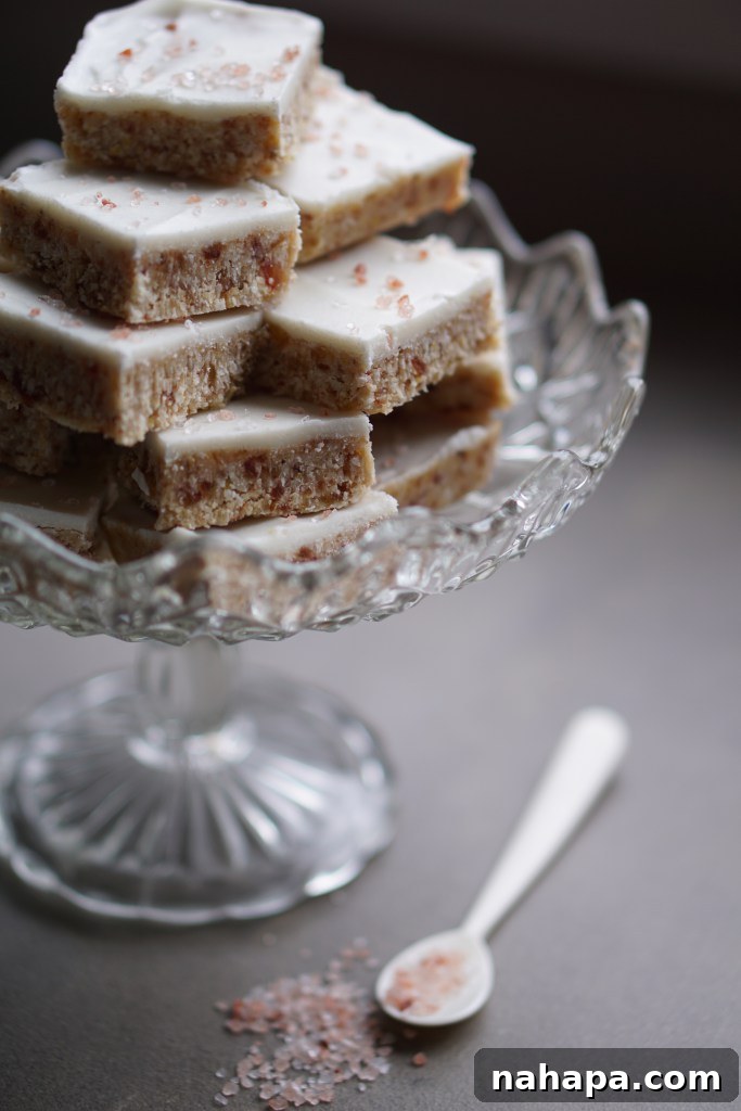 A stack of coconut orange and date bars on a glass platter.