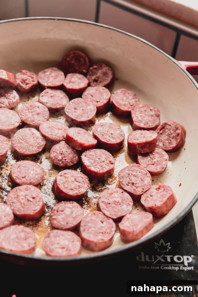 Down-Home Skillet Cabbage and Sausage 4 Chopped smoked sausage cooking in a hot skillet, developing a crispy crust.