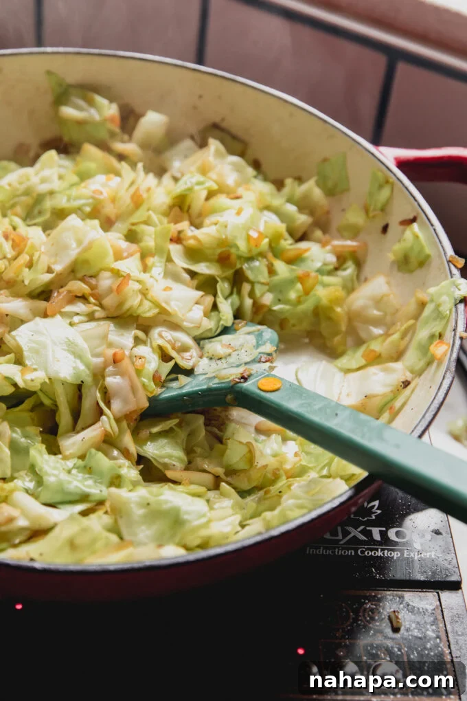Down-Home Skillet Cabbage and Sausage 6 Freshly chopped green cabbage being stir-fried in a large pan with other ingredients.