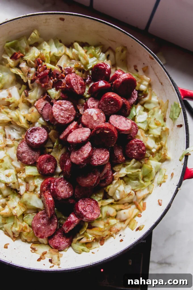 Down-Home Skillet Cabbage and Sausage 7 Cooked sausage and bacon mixed with tender cabbage in a skillet, ready for final seasoning.