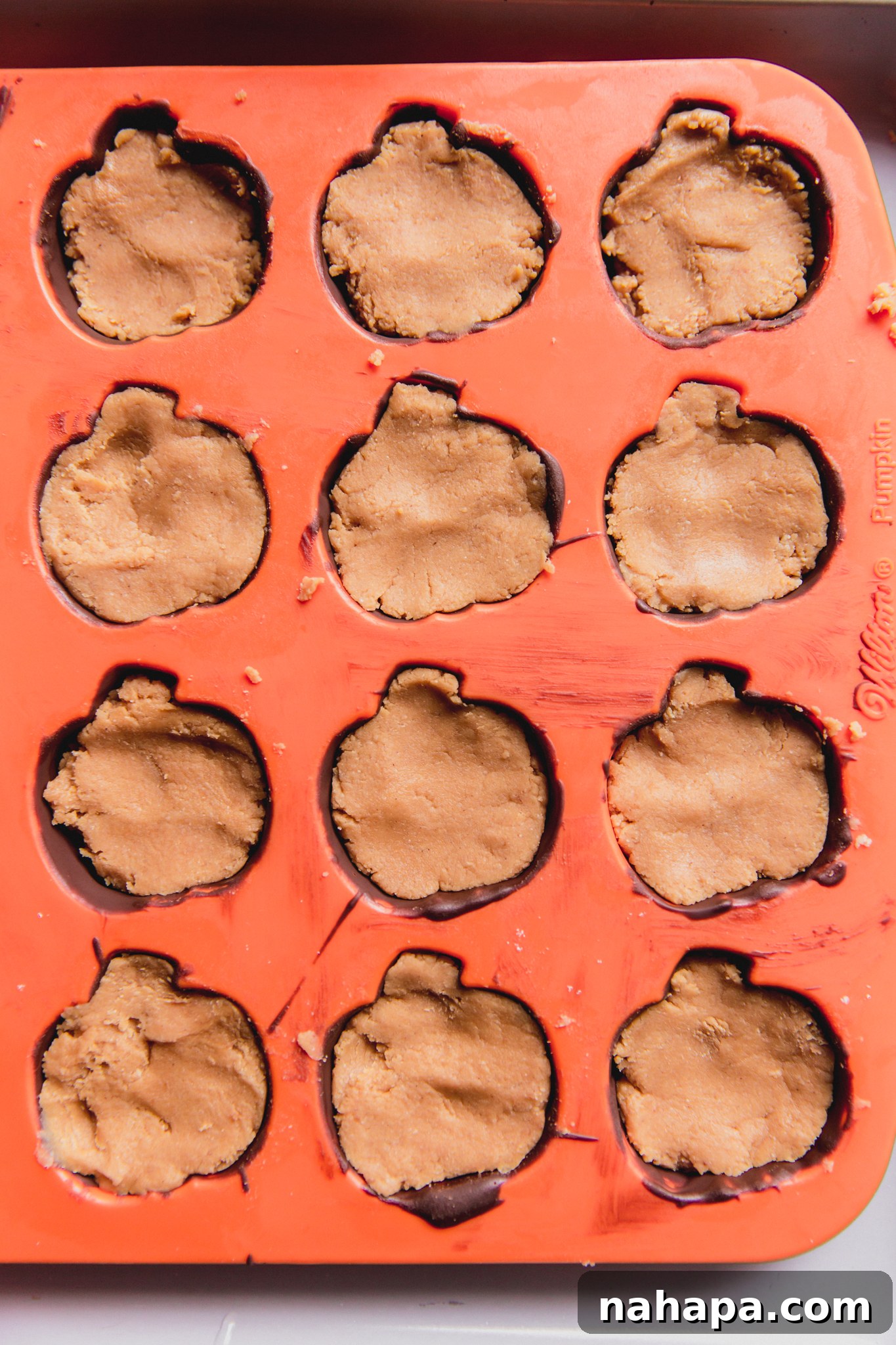 Pumpkin mold filled with the chocolate base and the pressed-in almond butter mixture.